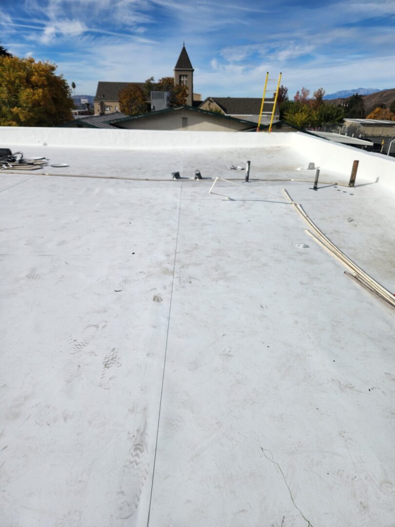 A white flat roof with a building in the background.